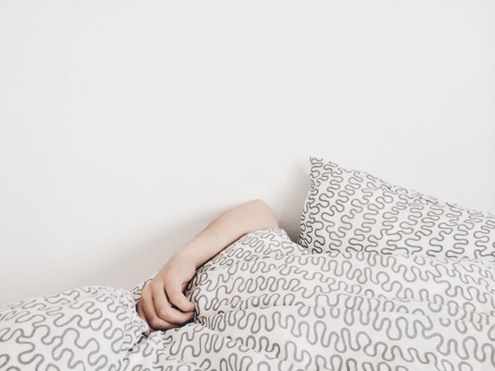 person resting from flu under blankets