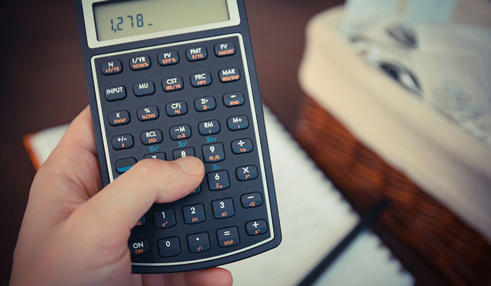 person inputting numbers into calculator for tax season