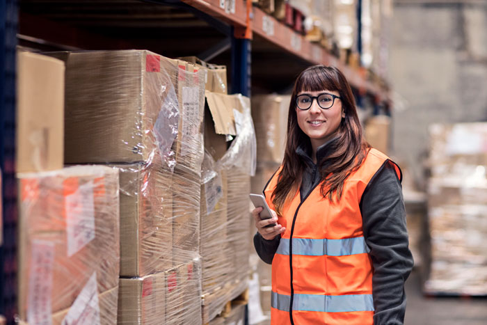 young female warehouse worker with long hair smiling